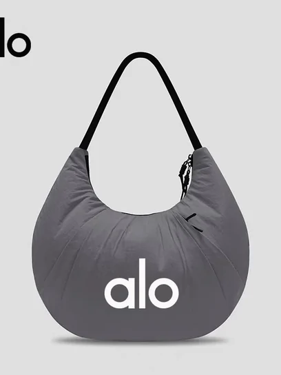 A soft grey shoulder bag with a curved base, photographed flat against white