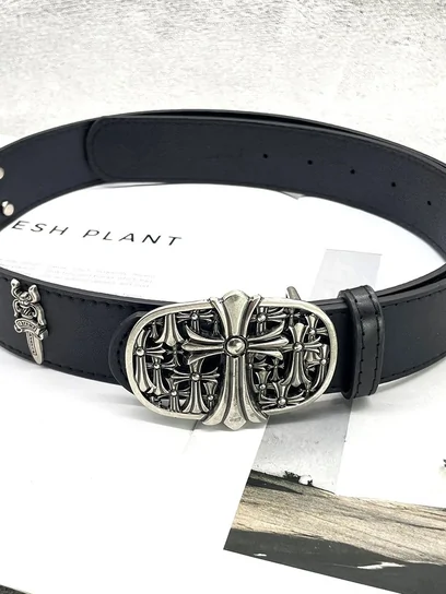 A black leather belt coiled on white with a large ornate silver buckle
