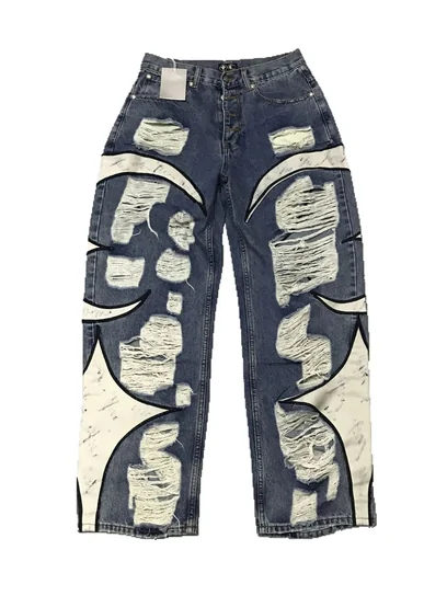 Dark denim jeans with large pale printed panels, laid flat on white