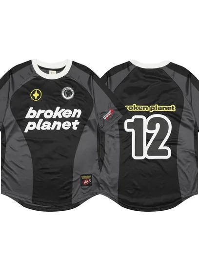Two football shirts laid side by side, one black with a printed chest graphic and one with the number twelve